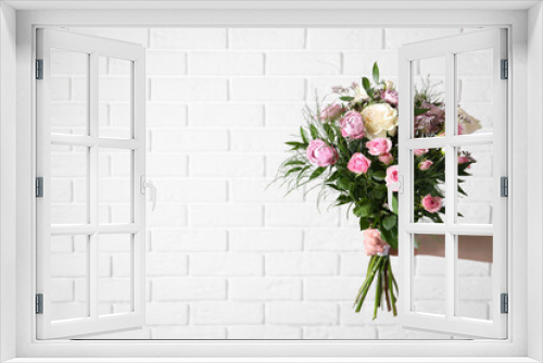 Fototapeta Naklejka Na Ścianę Okno 3D - Woman with bouquet of beautiful roses near white brick wall, closeup. Space for text
