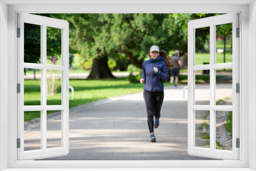 Young woman jogging in park on sunny day