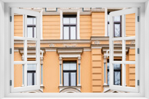 Fototapeta Naklejka Na Ścianę Okno 3D - Orange brick art nouveau building façade with nine cream windows in Riga, Latvia, Europe