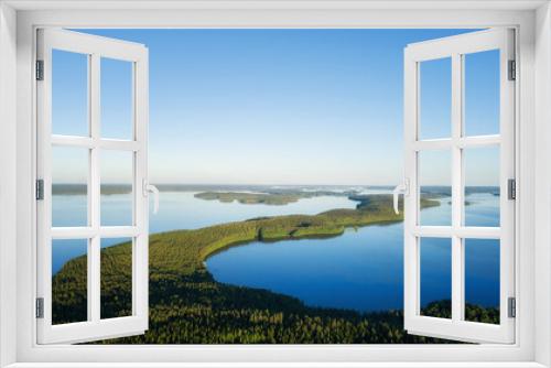 Fototapeta Naklejka Na Ścianę Okno 3D - Aerial top view of beautiful blue water of beautiful lake. Birds eye view of scenic lake surrounded by pine forests.