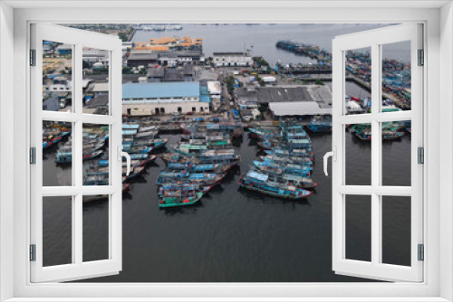 Fototapeta Naklejka Na Ścianę Okno 3D - Aerial drone view of Muara Angke Beach with wooden boats leaning beside the pier. With noise cloud after rain. Jakarta, Indonesia. March 21, 2021