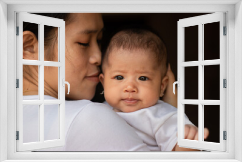 Young Asian mother kissing and holding little daughter in the park, Mother play enjoying with her cute baby girl in outdoor, copy space
