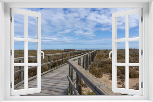 Fototapeta Naklejka Na Ścianę Okno 3D - wooden boardwalk leading through coastal marshlands and sand dunes