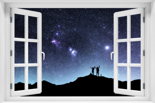 Fototapeta Naklejka Na Ścianę Okno 3D - Two hikers silhouettes stands on the hill and looking at the bright starry sky orion galaxy. Beautiful fantastic night landscape.