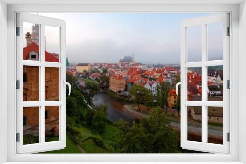Fototapeta Naklejka Na Ścianę Okno 3D - Scenery of Cesky Krumlov / Krumau old town on a foggy morning, with beautiful houses & towers in misty twilight and a church in the background, a UNESCO Heritage City by Vltava River in Czech Republic