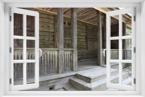 Fototapeta Naklejka Na Ścianę Okno 3D - Empty terrace with closed door and window with shutters on traditional ancient Russian log cabin old wooden house at summer day