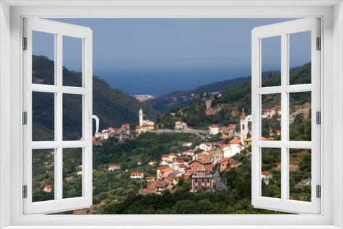 Wonderful view of the Italian village in the mountains. Against the background of the sea in the haze.