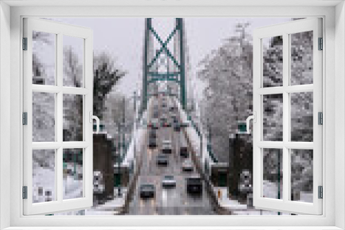 Fototapeta Naklejka Na Ścianę Okno 3D - Traffic on Lions Gate Bridge with snow covered trees in Stanley Park 