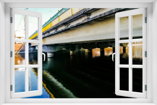 Fototapeta Naklejka Na Ścianę Okno 3D - Transport bridge over the river in the city with yellow-blue railings, side view