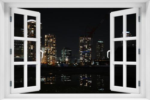 Fototapeta Naklejka Na Ścianę Okno 3D - ビルのある夜景とそれを映す水溜り