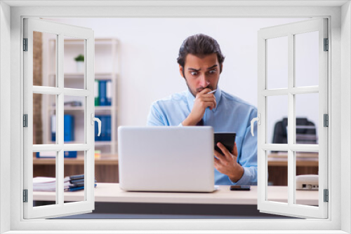 Young male bookkeeper working in the office