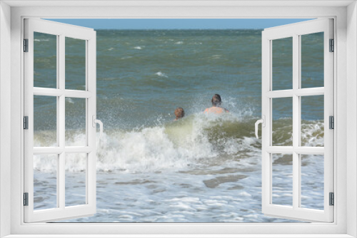 Fototapeta Naklejka Na Ścianę Okno 3D - Two children swim in the sea in the waves