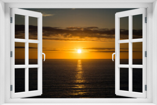 Fototapeta Naklejka Na Ścianę Okno 3D - A beautiful golden sunset over the ocean horizon on a warm summers evening.
