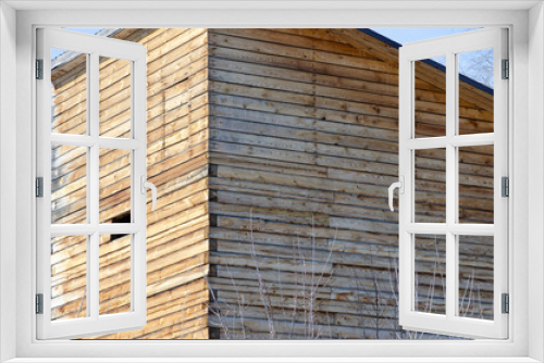 Fototapeta Naklejka Na Ścianę Okno 3D - House with a wooden facade, unfinished house. ecological building.