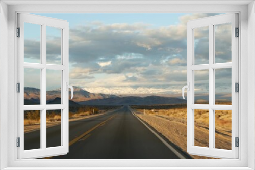 Fototapeta Naklejka Na Ścianę Okno 3D - Road trip, driving auto from Death Valley to Las Vegas, Nevada USA. Hitchhiking traveling in America. Highway journey, dramatic atmosphere, sunset mountain and Mojave desert wilderness. View from car.