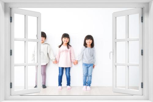 壁に並ぶ3人の子どもたち