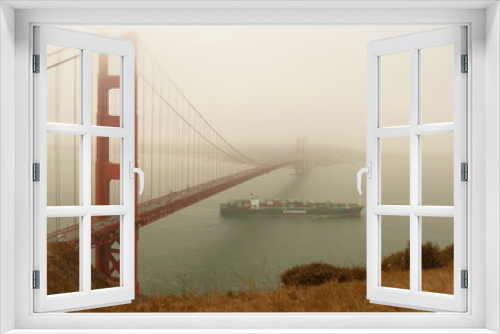 Fototapeta Naklejka Na Ścianę Okno 3D - High viewpoint of Golden Gate Bridge in some fog with ship passing underneath