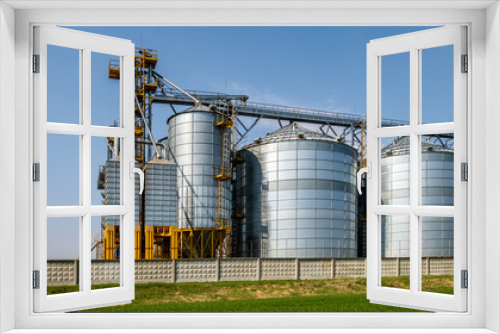 Fototapeta Naklejka Na Ścianę Okno 3D - Modern Granary elevator. Silver silos on agro-processing and manufacturing plant for processing drying cleaning and storage of agricultural products, flour, cereals and grain. seed cleaning line