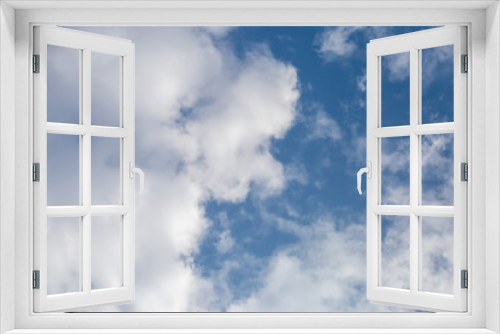 Soft white clouds in the close-up sky look dense, beautiful for background design, copy space available. Blue background