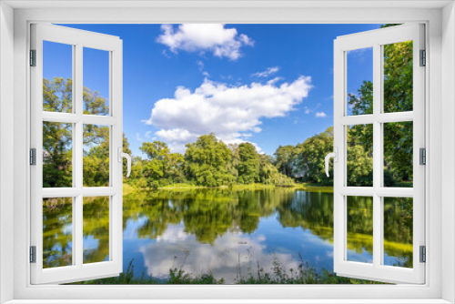 Fototapeta Naklejka Na Ścianę Okno 3D - Großer Teich mit blauem Himmel und weißen Wolken im Sommer