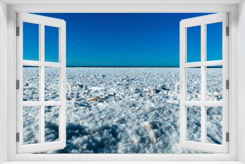 Fototapeta Naklejka Na Ścianę Okno 3D - winter landscape by the sea, ice pieces of different sizes, sea horizon in the distance, blue sky