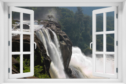 Fototapeta Naklejka Na Ścianę Okno 3D - A Dramatic high angle view of one of the gorgeous waterfalls of India flows majestically down the ravines to join the river near Kochi in Kerala,India.