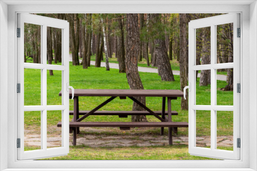 Fototapeta Naklejka Na Ścianę Okno 3D - Empty bench in the spring park. The perfect place to get away from urban problems.