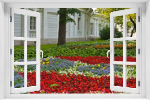 Fototapeta Naklejka Na Ścianę Okno 3D - St. Petersburg. City Park on Elagin Island. Magnificent flower composition on summer bed of colorful flowers in the shade of trees on a sunny day. Landscaping and city gardening