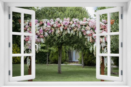 Fototapeta Naklejka Na Ścianę Okno 3D - Wedding ceremony. Very beautiful and stylish wedding arch, decorated with various fresh flowers, standing in the garden.
