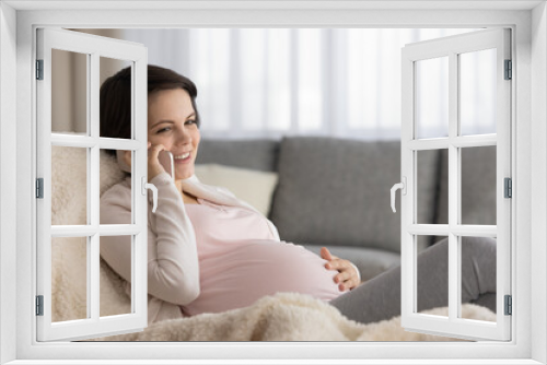 Smiling young pregnant woman relax at home on armchair talk speak on smartphone. Happy Caucasian female touch baby bump have pleasant cellphone call on device. Communication, motherhood concept.