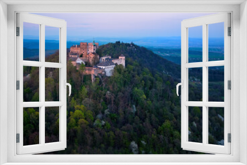 Fototapeta Naklejka Na Ścianę Okno 3D - Buchlov Castle. Aerial view on monumental castle in Romanesque Gothic style, standing on a wooded hill against Saint Barbara’s Chapel on the hill in background. Spring, tourism hot spot. Czech castles