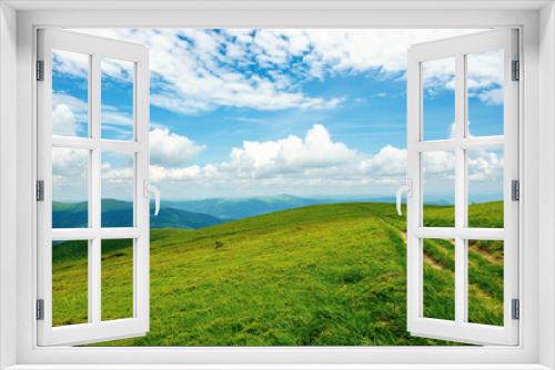 Fototapeta Naklejka Na Ścianę Okno 3D - country road through alpine meadow of carpathian mountain. beautiful nature landscape in summer. scenery with open view in to the distant ridge and valley. wonderful sky with clouds above the horizon