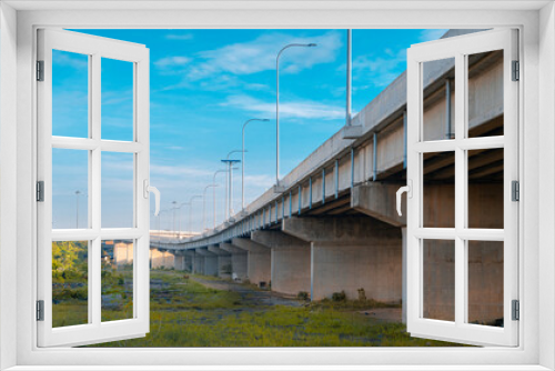 Fototapeta Naklejka Na Ścianę Okno 3D - Underneath the elevated Expressway concrete structure, greenery, and clear blue skies landscape view.