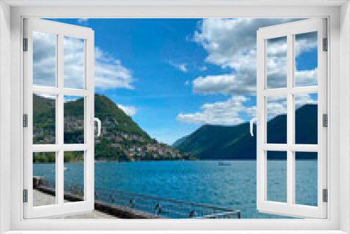 Fototapeta Naklejka Na Ścianę Okno 3D - Lake Lugano. Switzerland. City center, embankment. View of the lake and mountains. Sunny day, clouds. Wallpaper