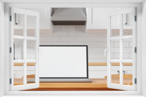 Modern laptop with white blank mockup screen on the dining table at cozy kitchen.