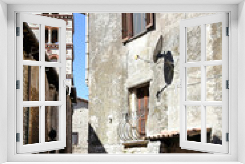 Fototapeta Naklejka Na Ścianę Okno 3D - Sermoneta, Italy, 05/10/2021. A street between old medieval stone buildings in the historic town.