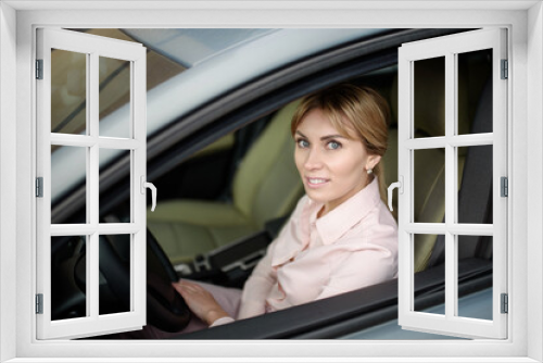 Happy and beautiful female driver driving a new car.New driver in town