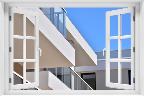 Fototapeta Naklejka Na Ścianę Okno 3D - Condominium and apartment building with  symmetrical modern architecture. Detail in modern residential flat apartment building exterior. Fragment of new luxury house and home complex. 