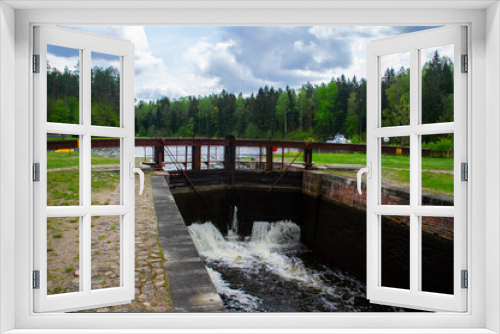Fototapeta Naklejka Na Ścianę Okno 3D - Old navigable river sluice. 20th century architecture with wooden mechanics. Augustow Canal, Belarus, 18 May 2021