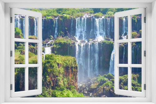 Fototapeta Naklejka Na Ścianę Okno 3D - Iguazu waterfalls in Argentina, view from Devil's Mouth. Panoramic view of many majestic powerful water cascades with mist and splashes. Panoramic image of Iguazu valley with lush subtropical forest.