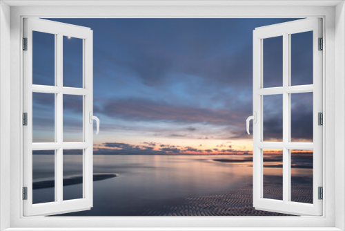 Fototapeta Naklejka Na Ścianę Okno 3D - Coastal sunset view with the long-shutter silky smooth seawater and scenic sky with clouds and focus on the sandbar texture in the front