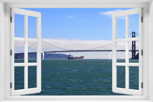 Fototapeta Naklejka Na Ścianę Okno 3D - A transport ship crossing the famous Golden Gate Bridge, San Francisco, California, USA 