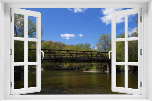 Fototapeta Naklejka Na Ścianę Okno 3D - Straight River and Pedestrian Overpass with bright blue sky and clouds at River Bend Nature Center.