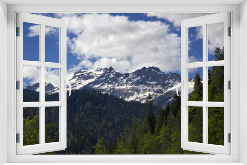 landscape mountains and forest in spring on blue sky background