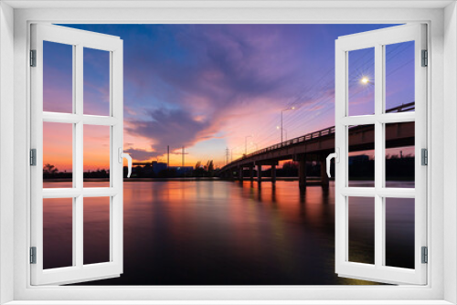 Fototapeta Naklejka Na Ścianę Okno 3D - bridge over river in the evening. The light from the lamp to the reflector surface,Container Terminal in Hamburg, Germany. Bridge is called Koehlbrandbruecke - a bridge about the harbor.