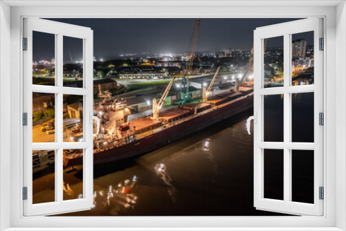 Fototapeta Naklejka Na Ścianę Okno 3D - A Transport Ship Docked at Night Awaiting Cargo Loading