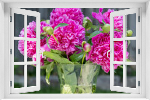 Fototapeta Naklejka Na Ścianę Okno 3D - Glass Vase of Dark Pink Peonies in a Garden Setting
