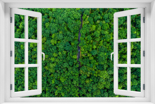 Fototapeta Naklejka Na Ścianę Okno 3D - alone car driving on asphalt road through a green forest. Drone top view. Aerial view landscape.
