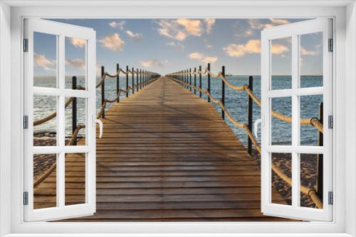 Fototapeta Naklejka Na Ścianę Okno 3D - Wooden pier extending into the sea at sunrise