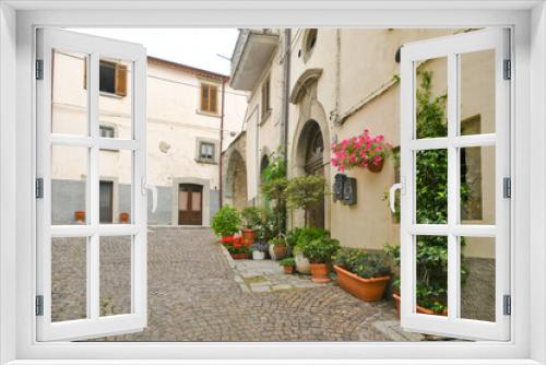 Fototapeta Naklejka Na Ścianę Okno 3D - A small street between the old houses of Agnone, a medieval village in the mountains of the Molise region, Italy.